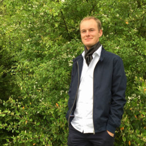 man with white shirt and polka dot black silk scarf